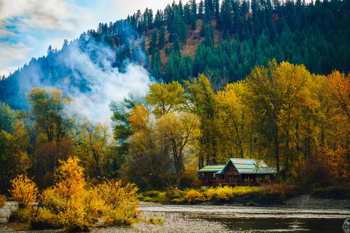 Riverside cabin beneath autumn trees, Leavenworth, Washington