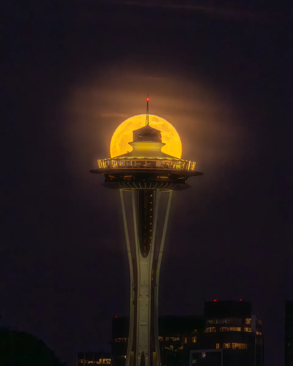 Full pink moon rising behind the Space Needle in Seattle